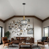 Living room with brown leather sofa, armchairs, and a wall of framed pictures.